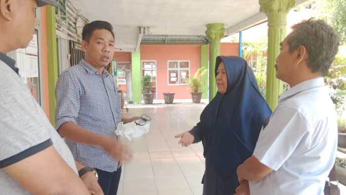 Orniando alias Ando (pegang kacamata) saat menemui warawan Sripo/Tribun, Leni Juwita di teras SMPN 1 OKU, Jumat (20/06/2025). foto: eko