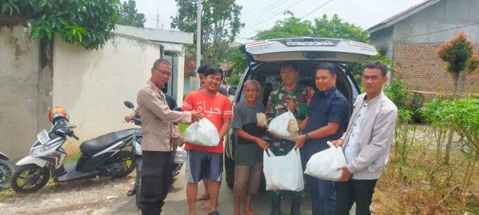 Kepala Desa Tanjung Baru, Subri Bustan ST bersama Bhabinkamtibmas dan Babinsa menyerahkan bantuan kepada warga terkena banjir, Kamis (31/07/2025). foto andi